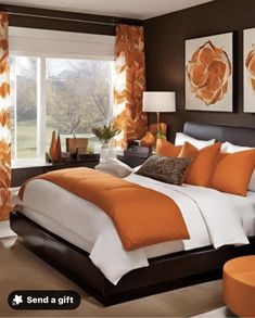 a bedroom with orange and white decor on the walls, bed in front of large window