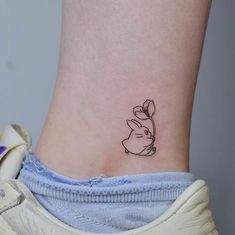 a small tattoo on the ankle of a woman's lower back side view,