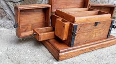 several wooden boxes are stacked on top of each other in front of a stone wall