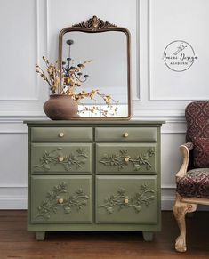 a green dresser sitting next to a chair with a mirror on it's side