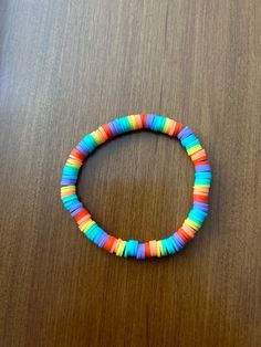 a colorful bracelet sitting on top of a wooden table