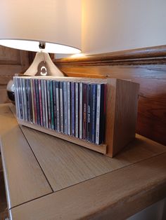 a wooden table with a lamp on top of it and a lot of cd's