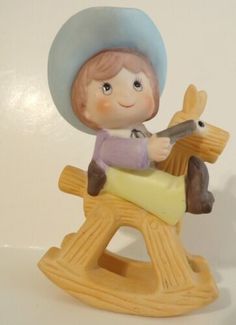 a figurine of a boy on a rocking horse