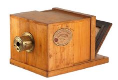 an old fashioned wooden box with a dial on it