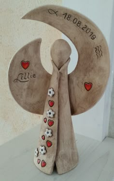 a wooden sculpture with hearts and flowers on it