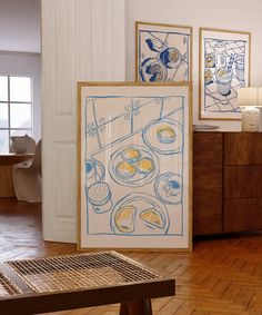 two framed art pieces on the wall in a room with wooden floors and wood flooring