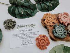 several pieces of crocheted hair on a wooden board next to some green leaves