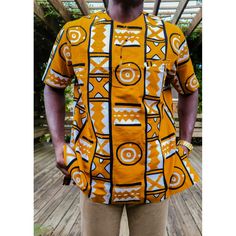 Our Adinkra African Print Short Sleeve Shirt Is An Essential Piece For Men. It Is Perfect For The Modern Man That Enjoys Elevating His African Wardrobe. This Very Stylish Piece Can Be Worn With Jeans Or Slacks To Bring Out The Look. Versatility Of The Design Goes With Any Style Of Wear. Description: Short Sleeve Shirt Hidden Front Pocket 100% African Wax Print Designed In The Usa, Imported From Ghana West African Dark Orange In Color Care Instruction: Dry Clean Only. Do Not Bleach. Iron Inside O Traditional Printed Yellow Tops, Traditional Short Sleeve Shirt With Graphic Print, Traditional Orange Cotton Tops, Mens African Wear Designs, African Print Shirts For Men, African Wear Designs, Men African Wear, African Wear For Men, African Print Shirt