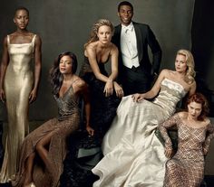 a group of women and men in formal wear posing for a photo with each other