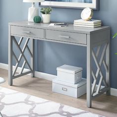 a gray desk with two drawers and a mirror on the wall in front of it