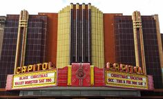 the marquee for capitol theatre is painted yellow and red with gold trimmings