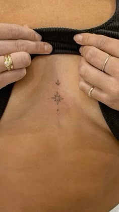 a woman is showing off her small tattoo on her stomach and the bottom part of her body