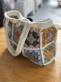 a crocheted purse sitting on top of a wooden table