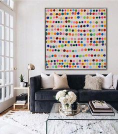 a living room filled with furniture and a large colorful painting on the wall above it