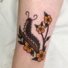 a close up of a person's arm with a tattoo on it and flowers