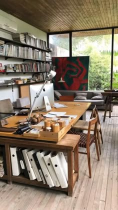 a room filled with lots of furniture and bookshelves next to a wooden floor