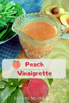 peach vinaigrette is in a glass bowl on a table with other fruits and vegetables