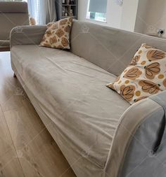 a couch with two pillows on it in a living room