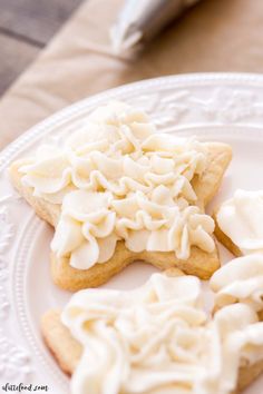 three cookies with white frosting on a plate