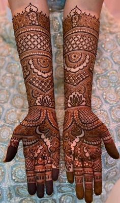 two hands with henna designs on them