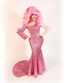 a woman with pink hair and makeup posing for the camera in a dress that has sequins on it