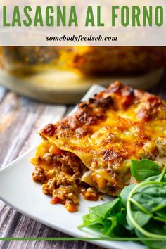 lasagna al forno with spinach and cheese on a white plate next to a green salad