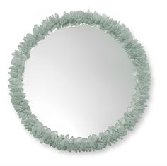 a circular mirror that is made out of green plastic beads on a white background,