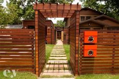 an open wooden gate leading to a house