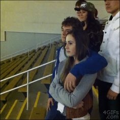 a group of people standing next to each other in front of a bleachers