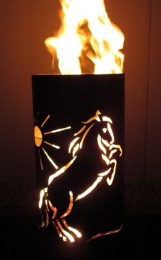 a lit up fire pit sitting on top of a black box with flames coming out of it