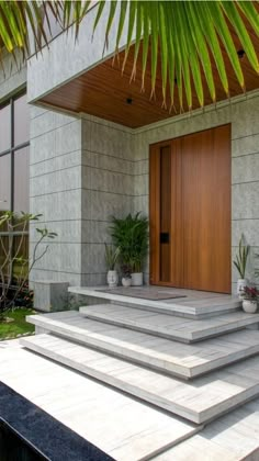 an entrance to a house with steps leading up to the door and planters on either side