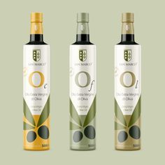 three bottles of olive oil on a green and white background with the label in gold