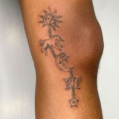 a woman's leg with tattoos on it and the sun in the sky above her