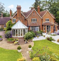 an aerial view of a large house with lots of flowers in the front and side yard