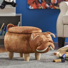 a stuffed animal sits on the floor in front of a toy elephant and wooden blocks