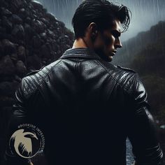 a man standing in the rain with his back to the camera, wearing a black leather jacket