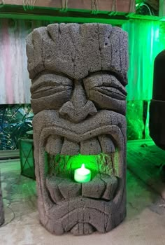 a tiki statue with a green light in it's mouth and eyes on display