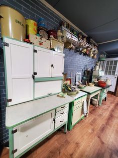 an old fashioned kitchen with green and white cabinets