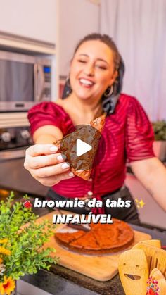 a woman holding up a piece of bread in her hand with the words brownie da tabs inaalveel on it