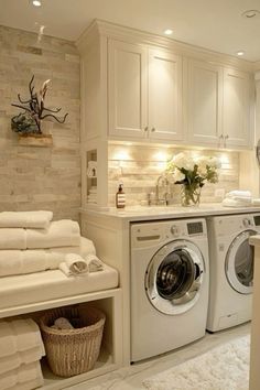 a washer and dryer in a white laundry room with towels on the rack