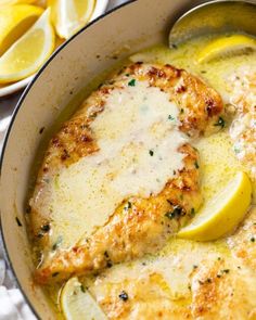 a pan filled with chicken and lemons on top of a table