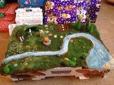 several presents are sitting on the floor in front of a table with a small river running through it