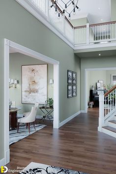 a living room filled with furniture and a stair case in front of a painting on the wall