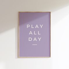 a purple poster with the words play all day in white letters on it against a wall