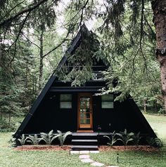 a - frame cabin in the woods with steps leading up to it's front door