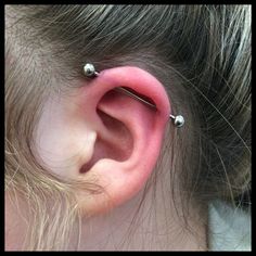 an ear with three piercings attached to it's side and the top part of its