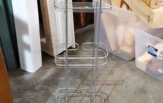 a three tiered metal rack sitting on top of a floor next to some boxes