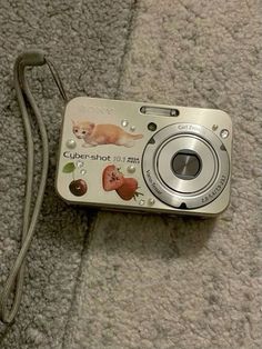 a silver camera sitting on top of a carpet