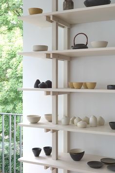 the shelves are filled with black and white bowls