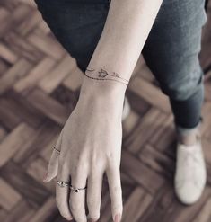 a woman's hand with a small tattoo on her left wrist and the word love written in cursive writing